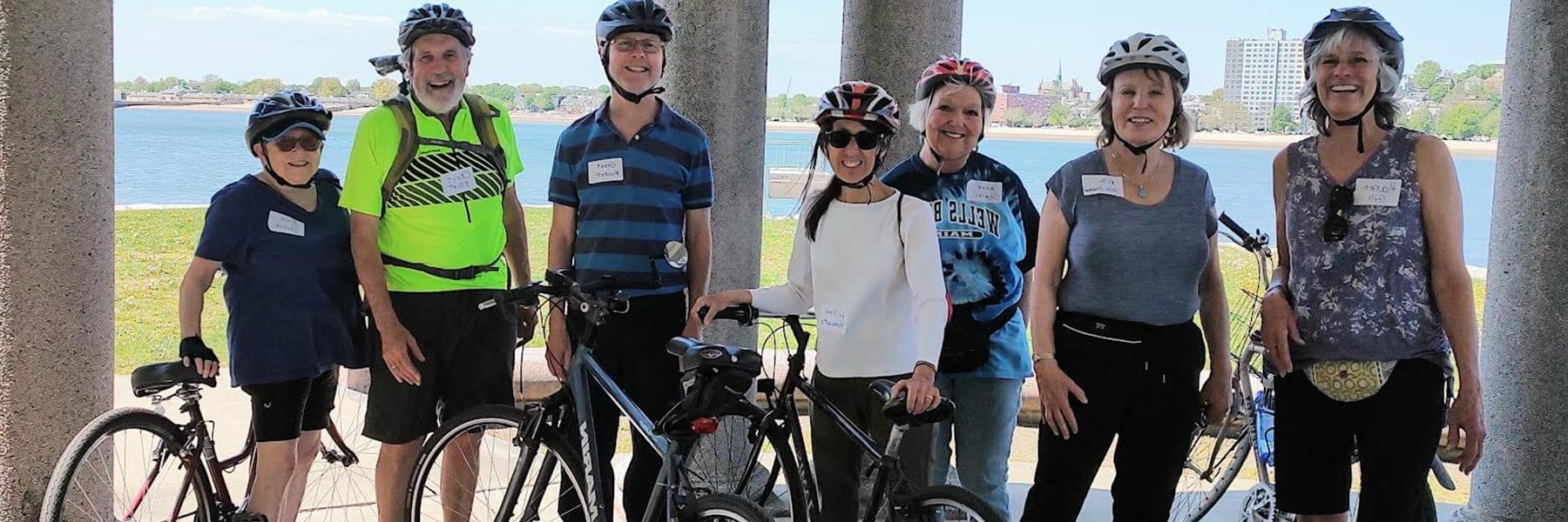 Older adults pose with bikes on the Harborwalk.